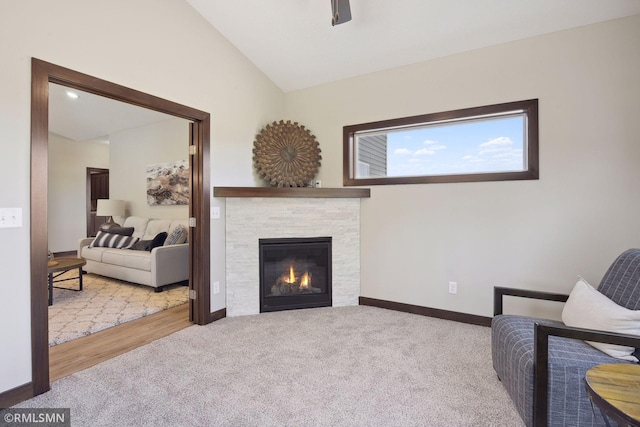 living area featuring lofted ceiling, light colored carpet, and a fireplace