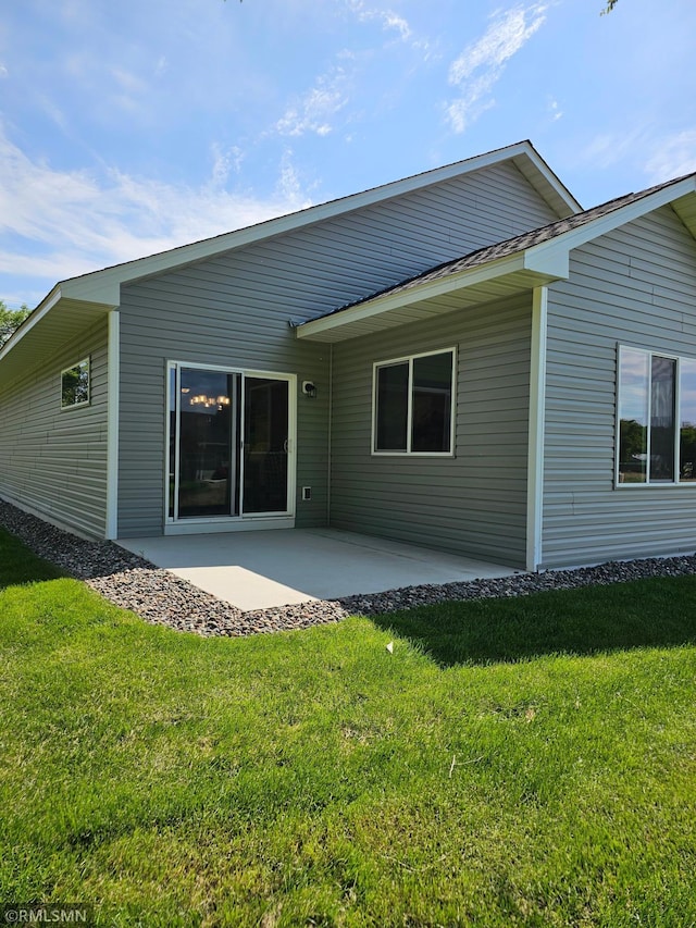 rear view of property featuring a patio area and a lawn