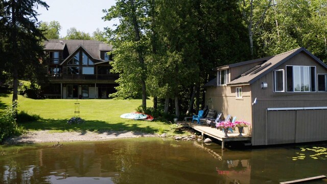 exterior space featuring a deck with water view and a yard