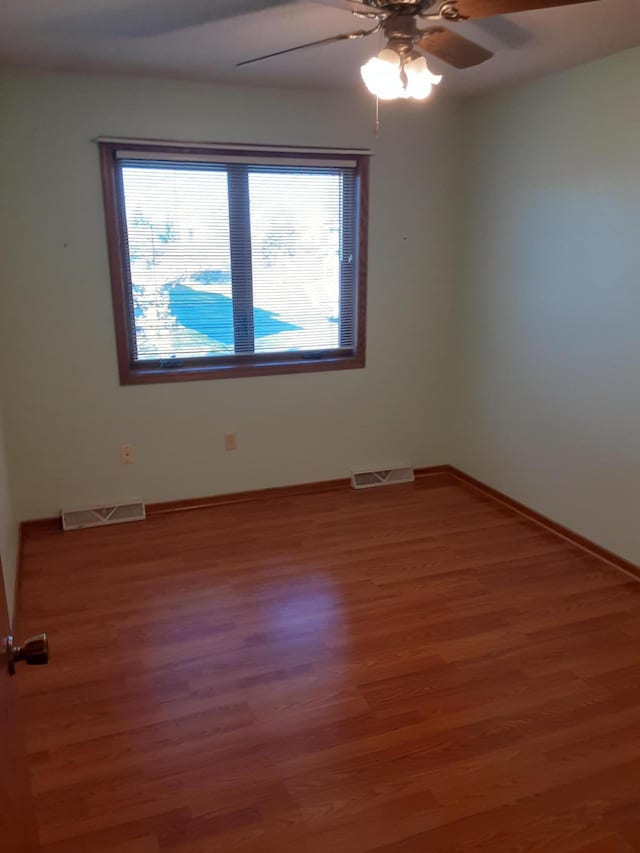 spare room with wood-type flooring and ceiling fan