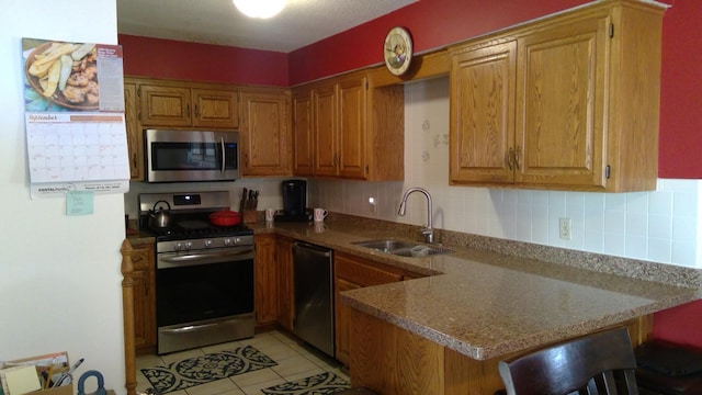 kitchen with a kitchen breakfast bar, light tile flooring, kitchen peninsula, appliances with stainless steel finishes, and sink