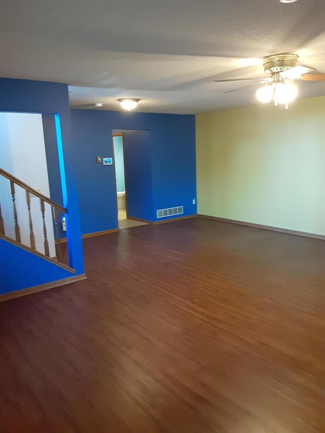 unfurnished room featuring ceiling fan and dark wood-type flooring