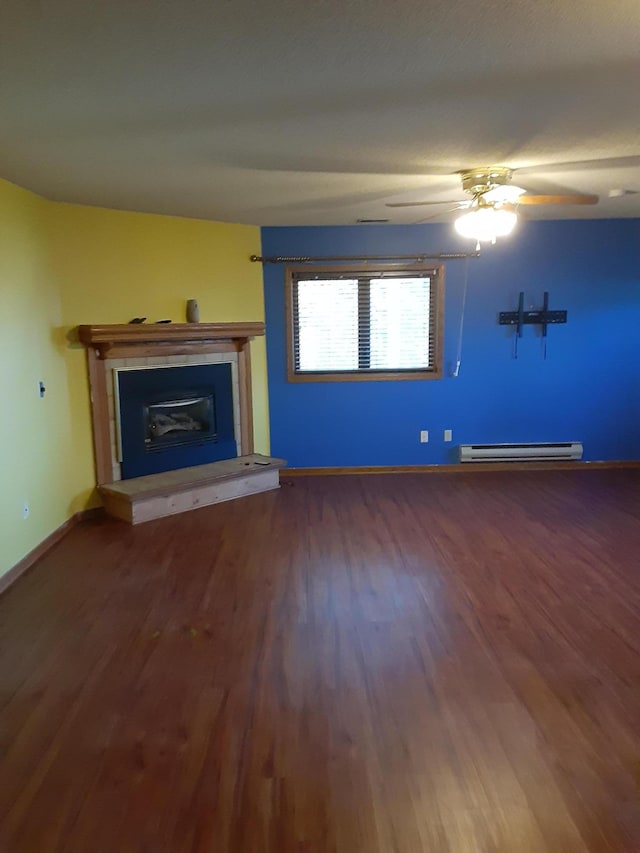 unfurnished living room with dark hardwood / wood-style floors, ceiling fan, and a baseboard heating unit