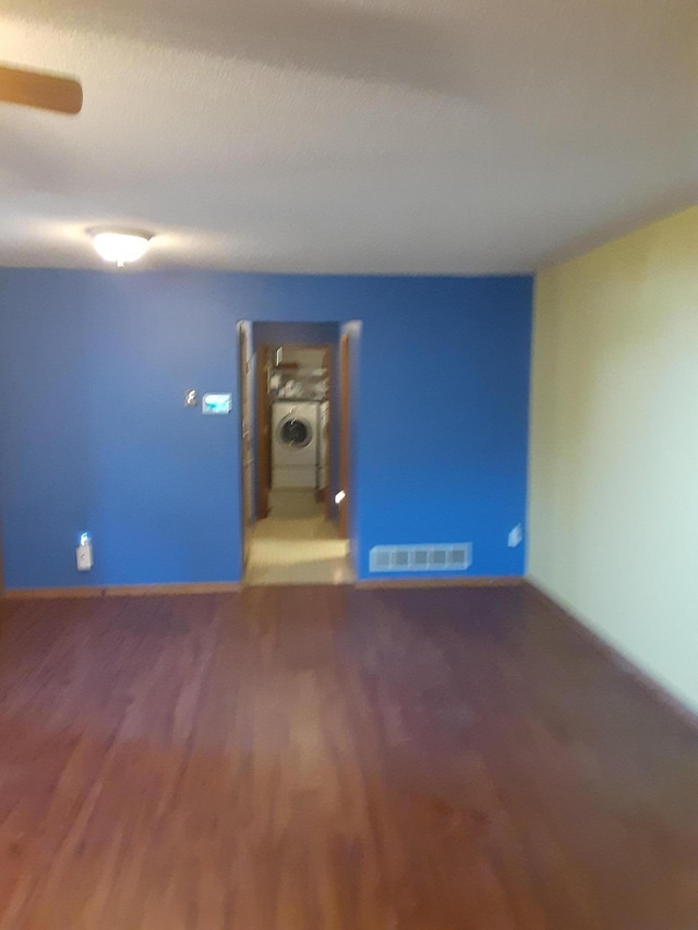 empty room featuring washer / clothes dryer and dark hardwood / wood-style flooring