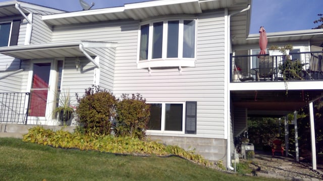 view of property exterior with a balcony and a yard