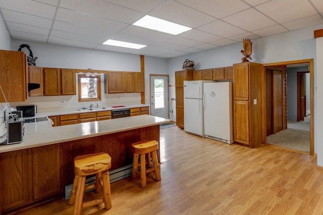 kitchen featuring white fridge, a drop ceiling, and light hardwood / wood-style floors