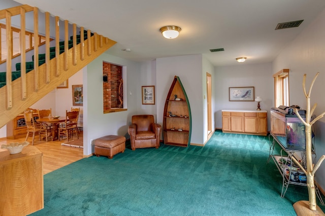 living area with brick wall and wood-type flooring