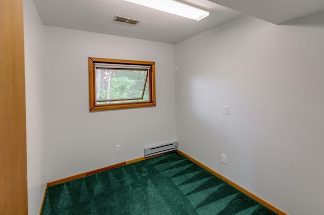 empty room featuring a textured ceiling, carpet, and a baseboard heating unit