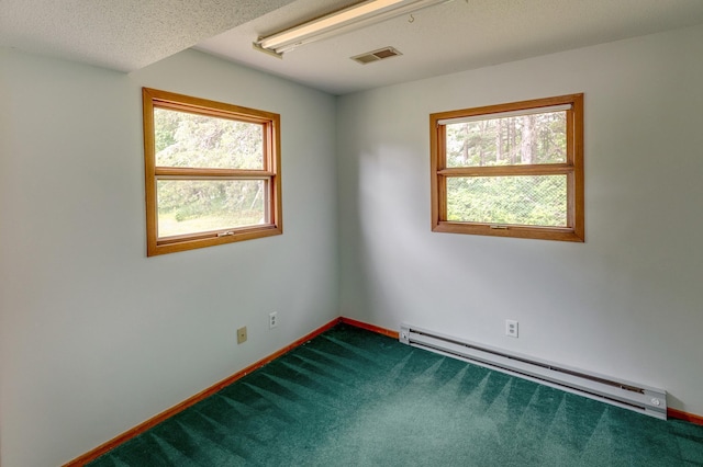 carpeted empty room with baseboard heating and a textured ceiling