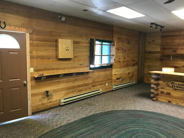 interior space featuring baseboard heating and wood walls