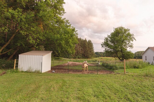 view of yard with a rural view and a storage unit