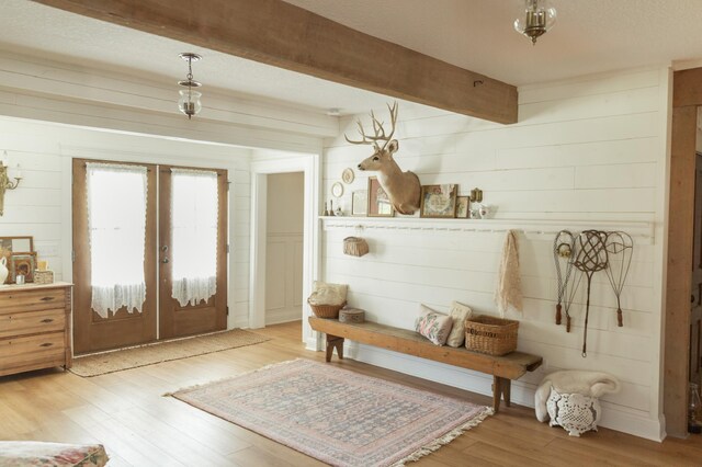 mudroom featuring hardwood / wood-style floors, wood walls, beamed ceiling, and french doors