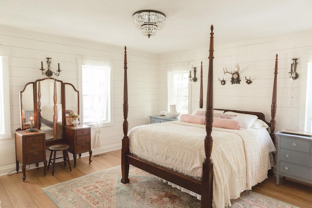 bedroom with multiple windows and light wood-type flooring