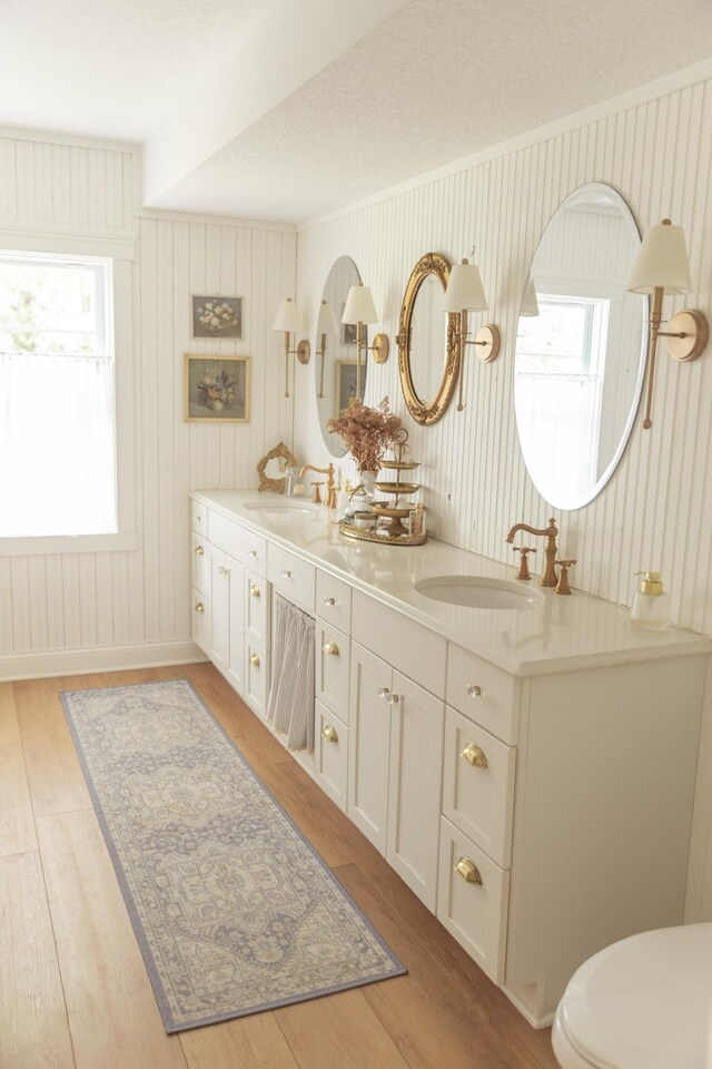 bathroom featuring wood-type flooring, vanity, and wood walls