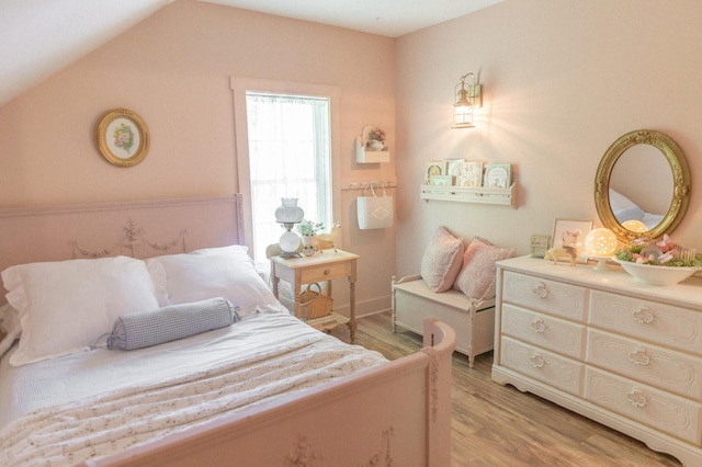 bedroom with lofted ceiling and light wood-type flooring