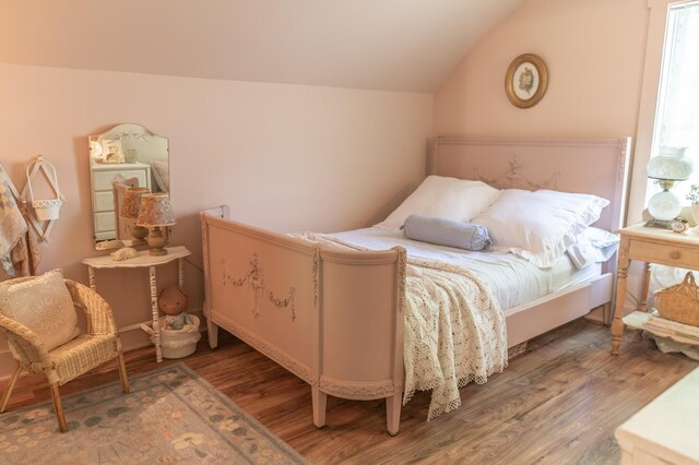 bedroom with dark hardwood / wood-style floors and vaulted ceiling