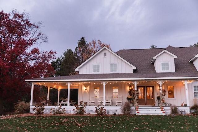 rear view of property featuring a lawn and covered porch