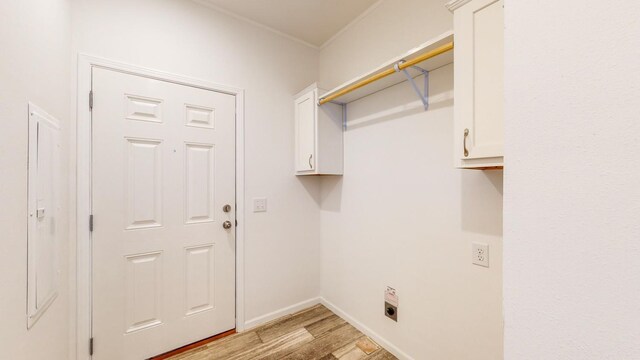 washroom with hookup for an electric dryer, light hardwood / wood-style flooring, and cabinets