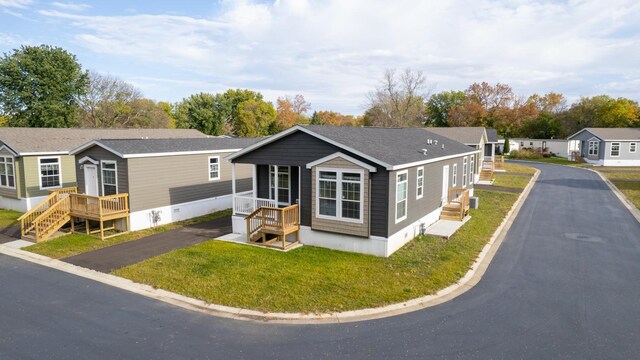 manufactured / mobile home with a front lawn and a wooden deck