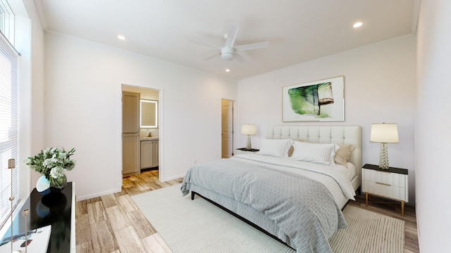 bedroom with ensuite bath, ceiling fan, multiple windows, and light hardwood / wood-style floors