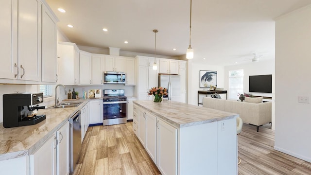 kitchen with white cabinetry, pendant lighting, appliances with stainless steel finishes, and a healthy amount of sunlight