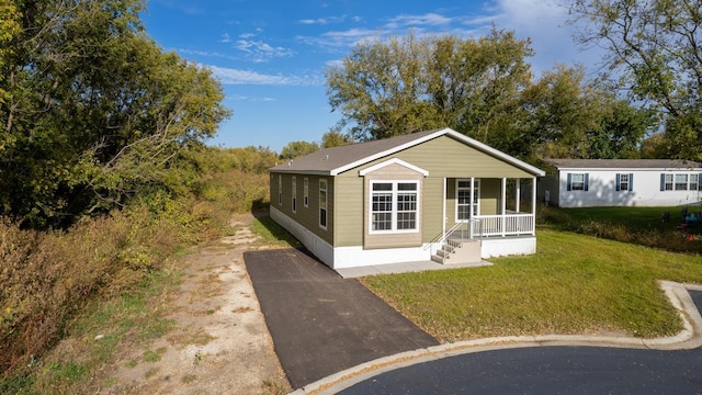 3611 85th St NW Unit 242, Oronoco Twp, MN 55960 - manufactured / mobile home with covered porch, driveway, and a front lawn