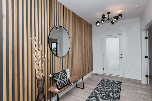 2811 Wildflower Ln SW, Rochester, MN 55902 - foyer entrance featuring light wood-type flooring, wallpapered walls, baseboards, and a chandelier