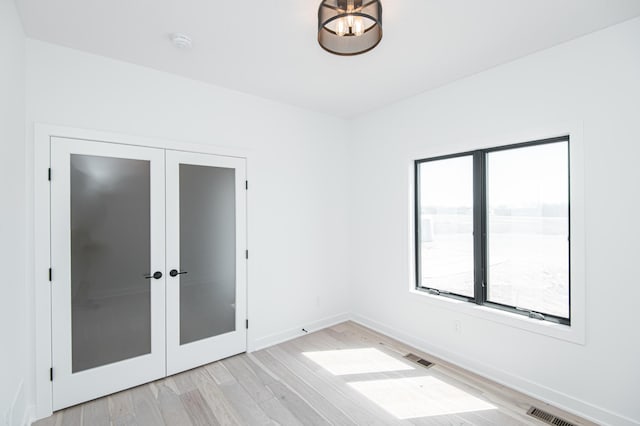 2811 Wildflower Ln SW, Rochester, MN 55902 - interior space featuring light wood-style flooring, visible vents, baseboards, and french doors
