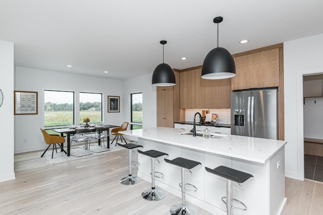2811 Wildflower Ln SW, Rochester, MN 55902 - kitchen featuring a sink, light wood-type flooring, modern cabinets, brown cabinets, and stainless steel fridge with ice dispenser