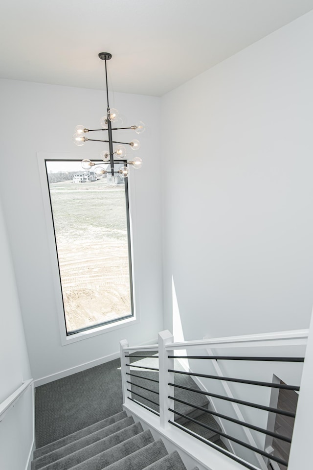2811 Wildflower Ln SW, Rochester, MN 55902 - staircase featuring baseboards, carpet, and a chandelier