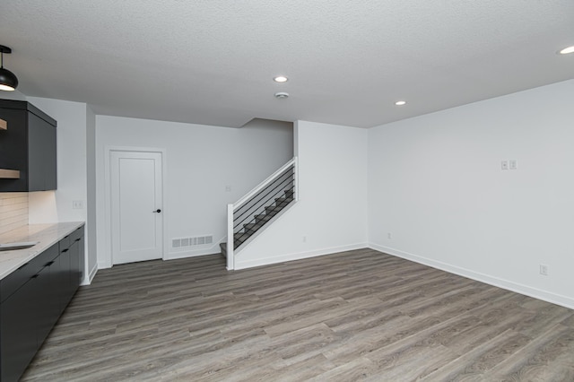 2811 Wildflower Ln SW, Rochester, MN 55902 - unfurnished living room with recessed lighting, wood finished floors, visible vents, and stairs