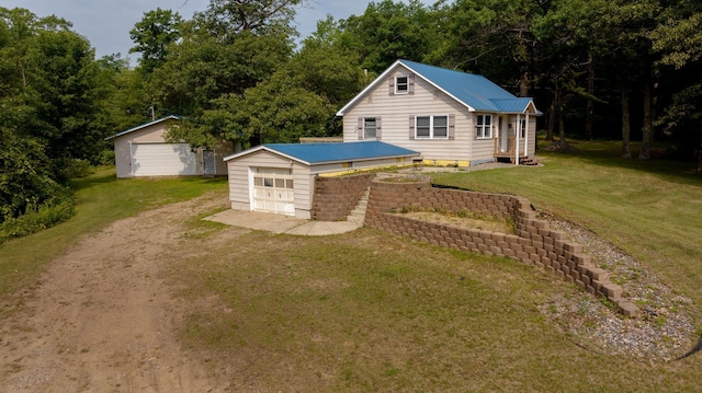 view of front facade with an outbuilding, a garage, and a front lawn