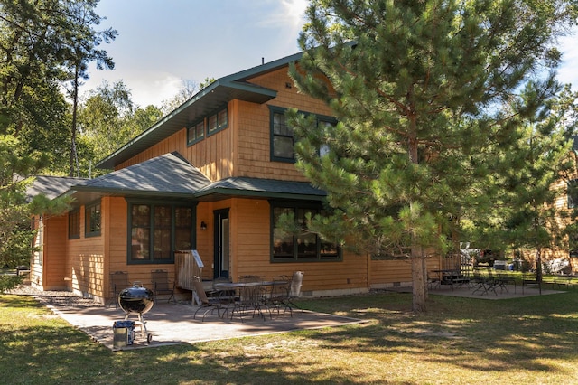 rear view of property with a lawn and a patio area