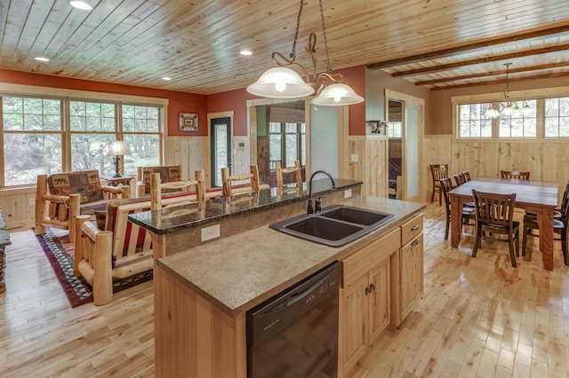 kitchen featuring dishwasher, a kitchen island with sink, sink, hanging light fixtures, and light hardwood / wood-style flooring