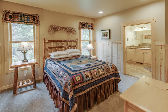 bedroom with ensuite bathroom and wooden walls