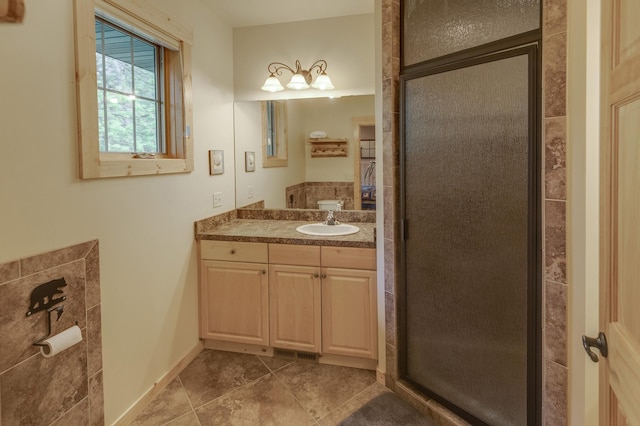 bathroom with tile patterned flooring, vanity, and walk in shower