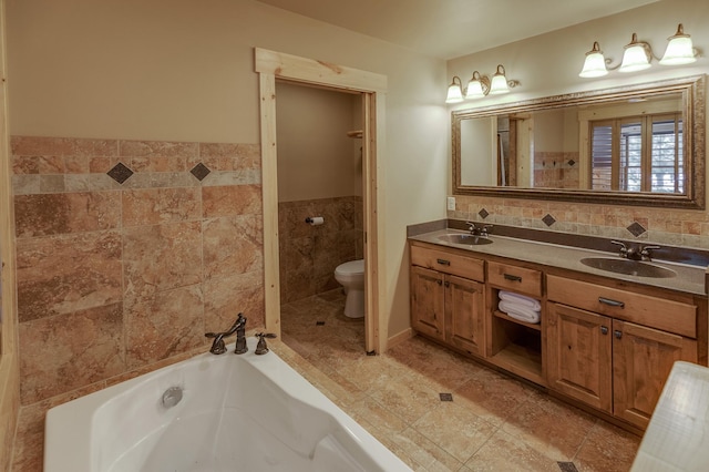 bathroom featuring vanity, toilet, a tub, and tile walls