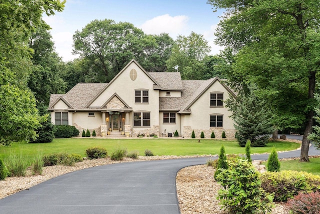 french country inspired facade featuring a front lawn