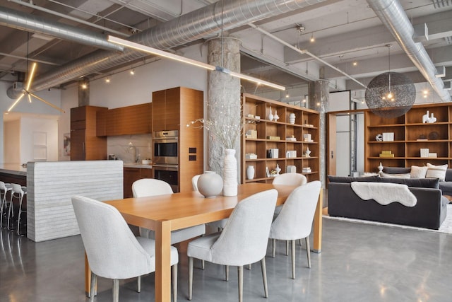 dining space featuring sink and a high ceiling