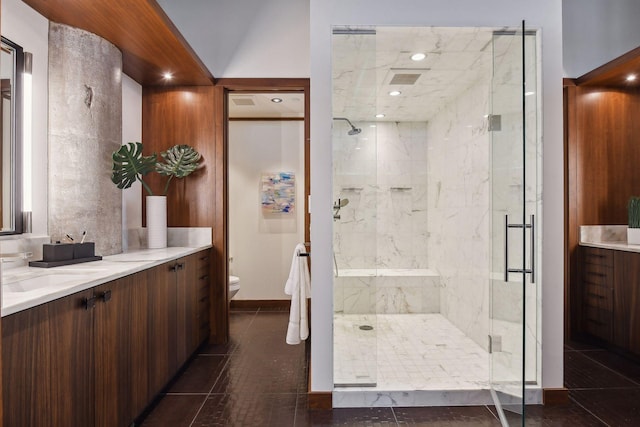 bathroom with tile patterned flooring, vanity, toilet, and a shower with door