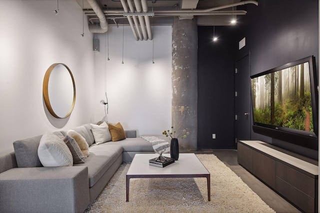 living room with concrete flooring and a high ceiling