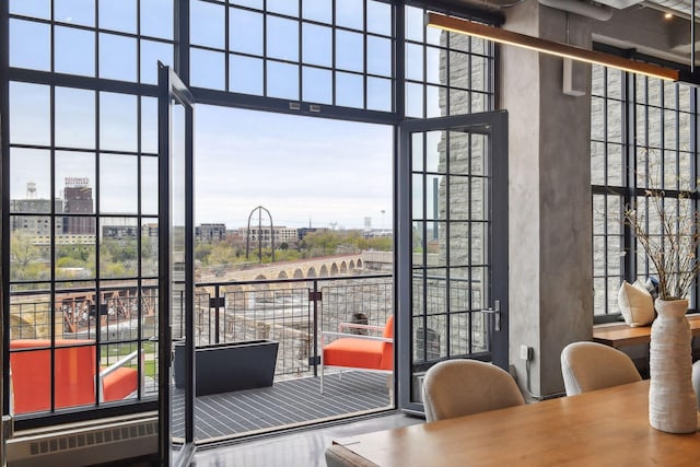 doorway to outside with a high ceiling, a wealth of natural light, and radiator