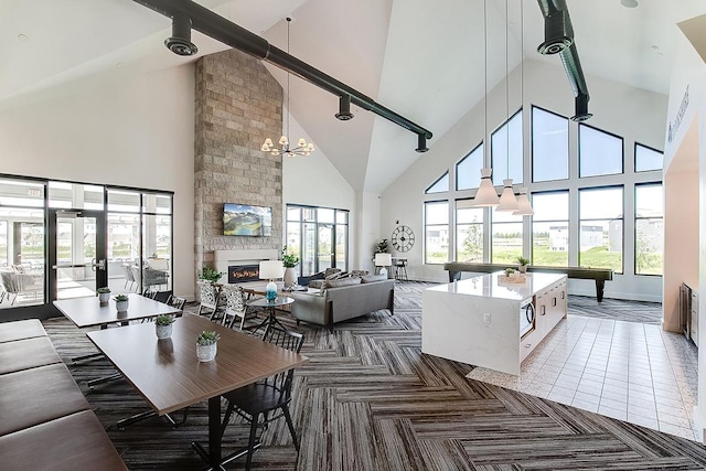 living room with a large fireplace, an inviting chandelier, high vaulted ceiling, beamed ceiling, and pool table