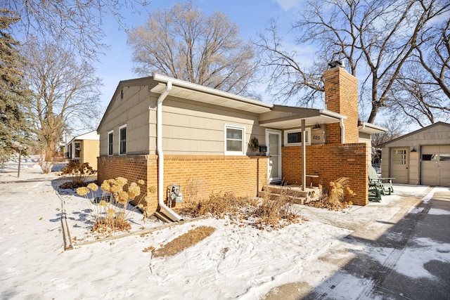 625 5th Ave S, Hopkins, MN 55343 - view of front of house featuring brick siding, a chimney, an outdoor structure, and a detached garage