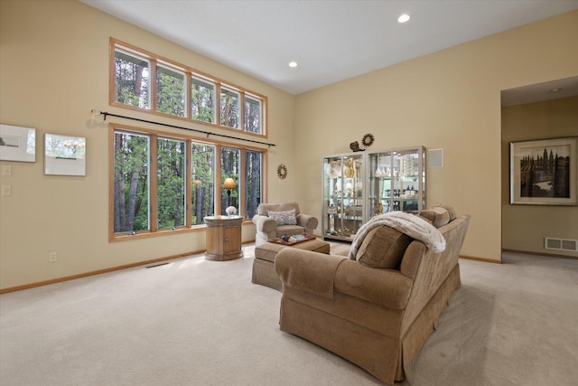 carpeted living room with a high ceiling