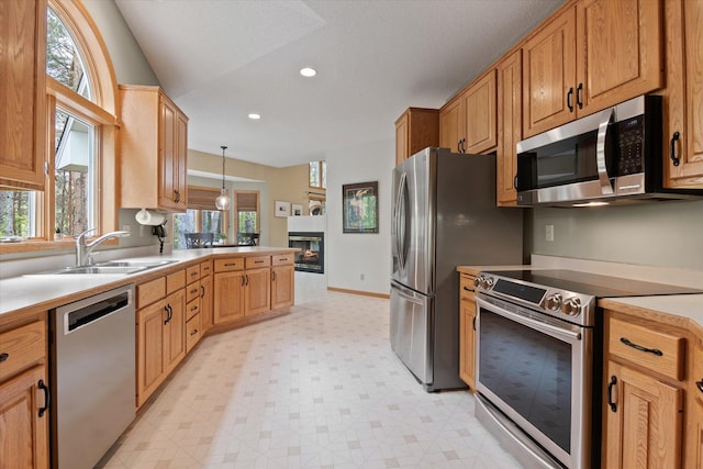 kitchen with light tile flooring, a healthy amount of sunlight, hanging light fixtures, and appliances with stainless steel finishes