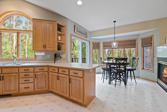 kitchen featuring plenty of natural light, sink, light tile floors, and pendant lighting