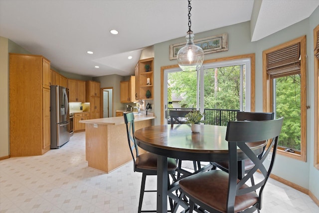 dining space featuring sink and light tile floors