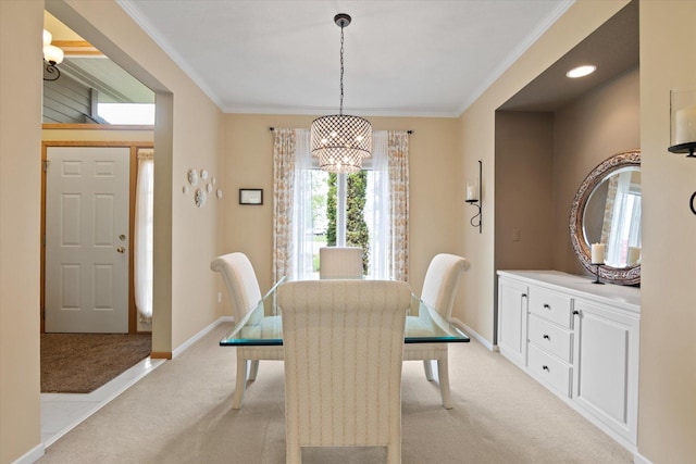 dining space with an inviting chandelier, crown molding, and light colored carpet