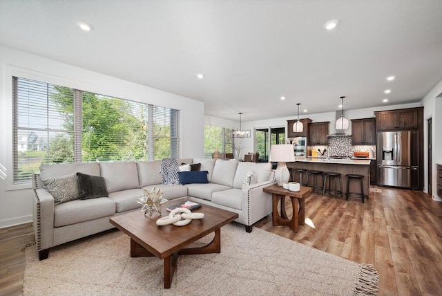 living room featuring light hardwood / wood-style flooring and an inviting chandelier